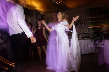 the first dance of the bride and groom inside a restaurant with heavy smoke