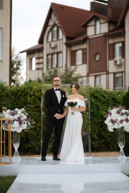 wedding ceremony of the newlyweds on the glade near the restaurant