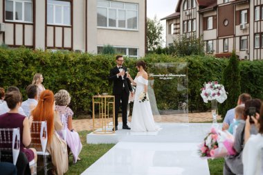 wedding ceremony of the newlyweds on the glade near the restaurant