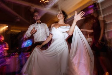 the first dance of the bride and groom inside a restaurant with heavy smoke