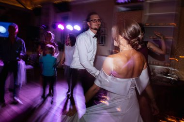 the first dance of the bride and groom inside a restaurant with heavy smoke