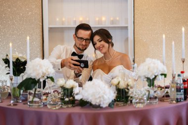 Yeni evlilerin portresi düğün şöleninde başkanlık makamında.