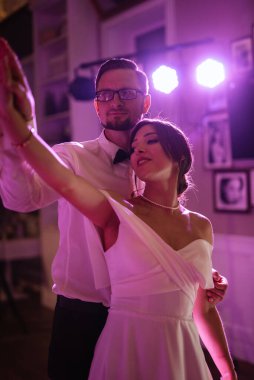 the first dance of the bride and groom inside a restaurant with heavy smoke