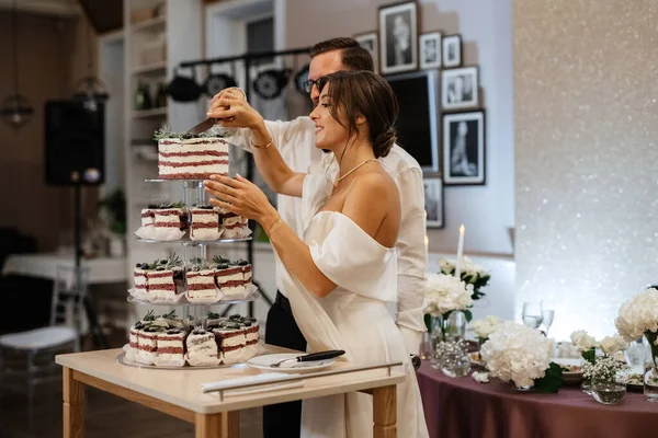 新婚旅行は喜んで結婚式のケーキを切って笑って味わう — ストック写真