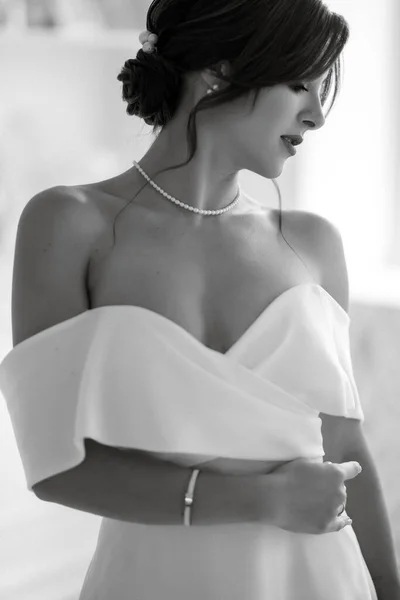 ブルネット花嫁でタイトウェディングドレスで明るいスタジオで花束 — ストック写真