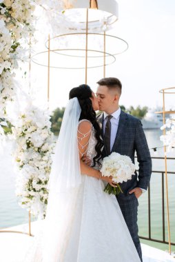 wedding ceremony of the newlyweds on the pier near the restaurant