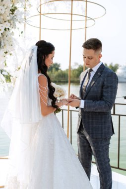 wedding ceremony of the newlyweds on the pier near the restaurant