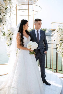wedding ceremony of the newlyweds on the pier near the restaurant