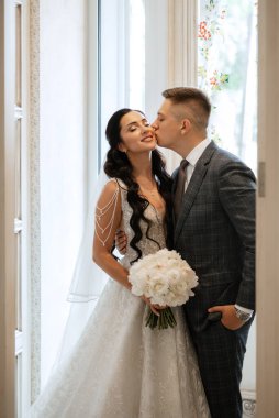 Gelin ve damat bir kokteyl barının içinde. Parlak bir atmosferde, bir bardak içkiyle.