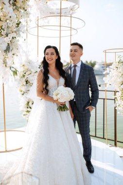 wedding ceremony of the newlyweds on the pier near the restaurant