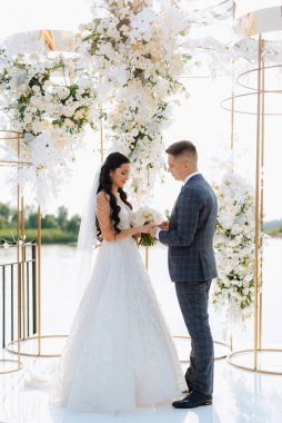 wedding ceremony of the newlyweds on the pier near the restaurant