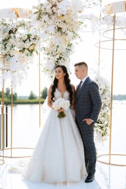 wedding ceremony of the newlyweds on the pier near the restaurant