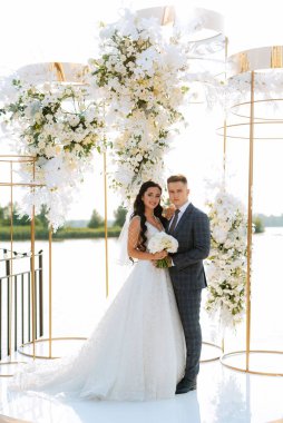 wedding ceremony of the newlyweds on the pier near the restaurant