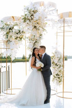 wedding ceremony of the newlyweds on the pier near the restaurant