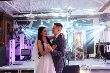 the first dance of the bride and groom inside a restaurant with heavy smoke