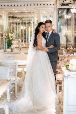 Gelin ve damat bir kokteyl barının içinde. Parlak bir atmosferde, bir bardak içkiyle.