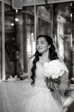 Parlak bir kafede aynalı beyaz elbiseli bir gelinin portresi.