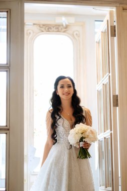 Parlak bir kafede aynalı beyaz elbiseli bir gelinin portresi.