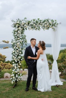 Yeni evlilerin düğün töreni yeşil bir tepedeki kır evinde.