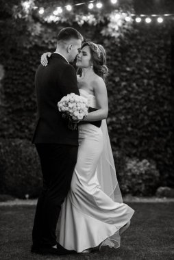 Bir kır evinde düğün günü genç bir gelin ve damadın portresi.