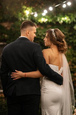 Bir kır evinde düğün günü genç bir gelin ve damadın portresi.