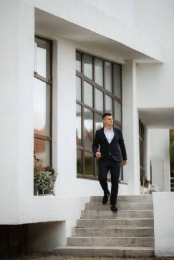 Koyu renk yün takım elbiseli bir damadın portresi.