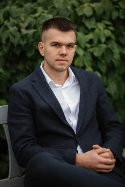 Koyu renk yün takım elbiseli bir damadın portresi.