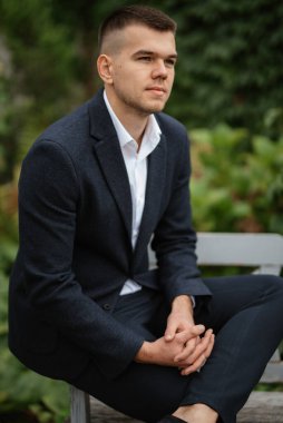 Koyu renk yün takım elbiseli bir damadın portresi.