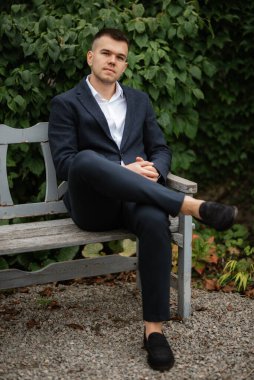 Koyu renk yün takım elbiseli bir damadın portresi.