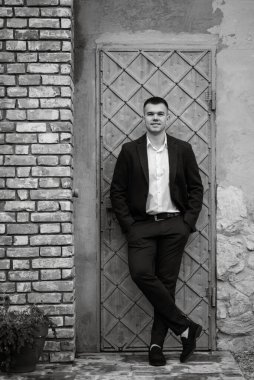 Koyu renk yün takım elbiseli bir damadın portresi.