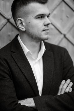 Koyu renk yün takım elbiseli bir damadın portresi.