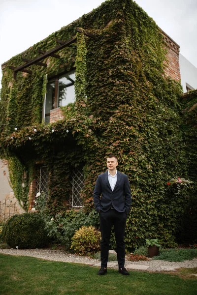 stock image portrait of a young guy groom in a dark wool suit