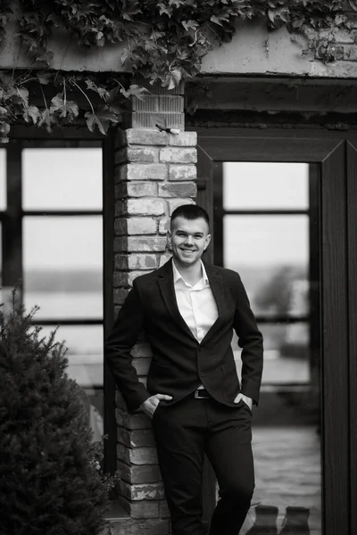 stock image portrait of a young guy groom in a dark wool suit