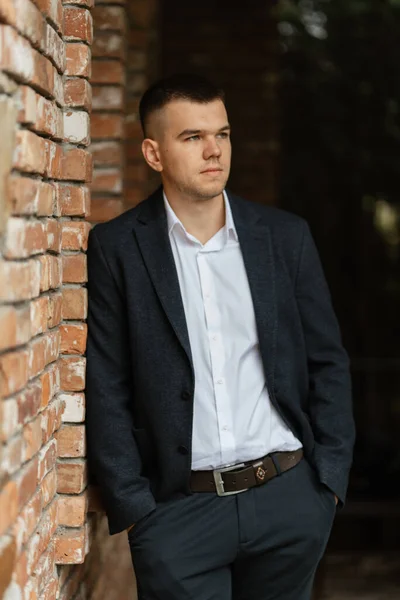 stock image portrait of a young guy groom in a dark wool suit