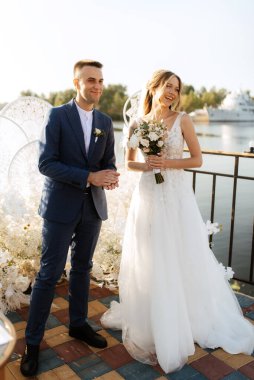 wedding ceremony of the newlyweds on the pier near the restaurant