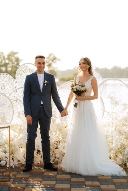 wedding ceremony of the newlyweds on the pier near the restaurant