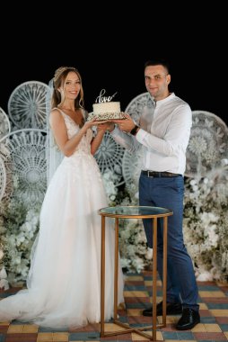 newlyweds happily cut, laugh and taste the wedding cake