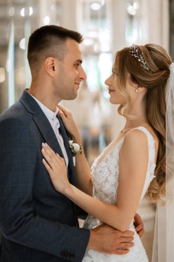 Gelin ve damat bir kokteyl barının içinde. Parlak bir atmosferde, bir bardak içkiyle.