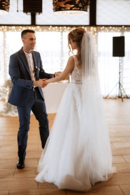 Gelin ve damadın ilk düğün dansı gün batımında restoranın içinde.