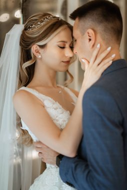 Gelin ve damat bir kokteyl barının içinde. Parlak bir atmosferde, bir bardak içkiyle.