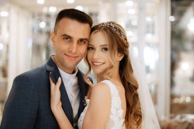 Gelin ve damat bir kokteyl barının içinde. Parlak bir atmosferde, bir bardak içkiyle.