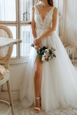 Parlak bir kafede aynalı beyaz elbiseli bir gelinin portresi.