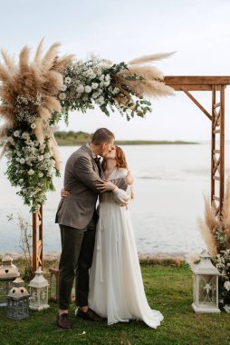 Yeni evlilerin düğün töreni yeşil bir tepedeki kır evinde.