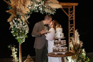 newlyweds happily cut, laugh and taste the wedding cake