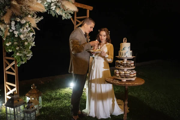 newlyweds happily cut, laugh and taste the wedding cake
