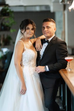 Gelin ve damat, canlı bir atmosferde bir kokteyl barında.