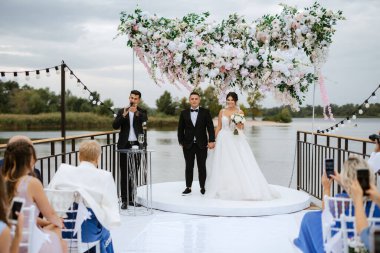 wedding ceremony of the newlyweds on the pier near the restaurant