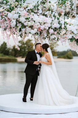 wedding ceremony of the newlyweds on the pier near the restaurant