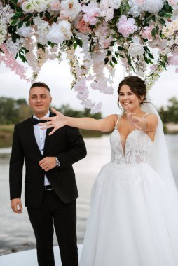 wedding ceremony of the newlyweds on the pier near the restaurant