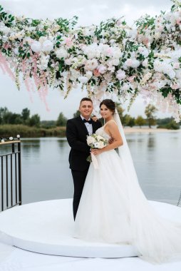wedding ceremony of the newlyweds on the pier near the restaurant